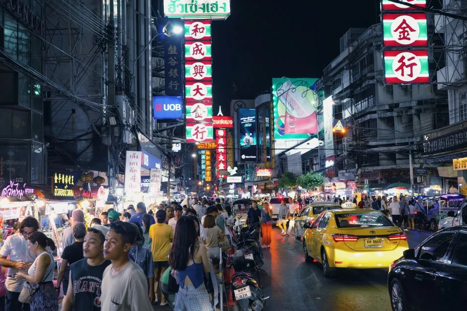 Lively city street at night with crowds, neon lights, and busy traffic. Immersive urban experience.