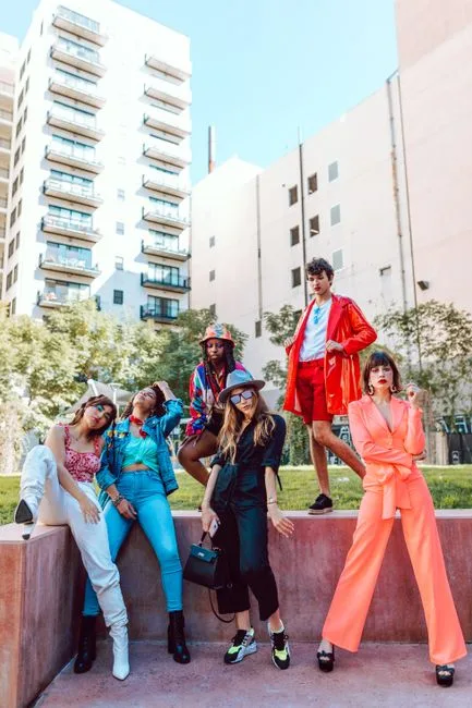 A diverse group of fashionable young adults expressing individuality and style in an urban setting.