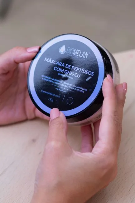 Close-up of hands holding peptide mask container from Belo Horizonte.