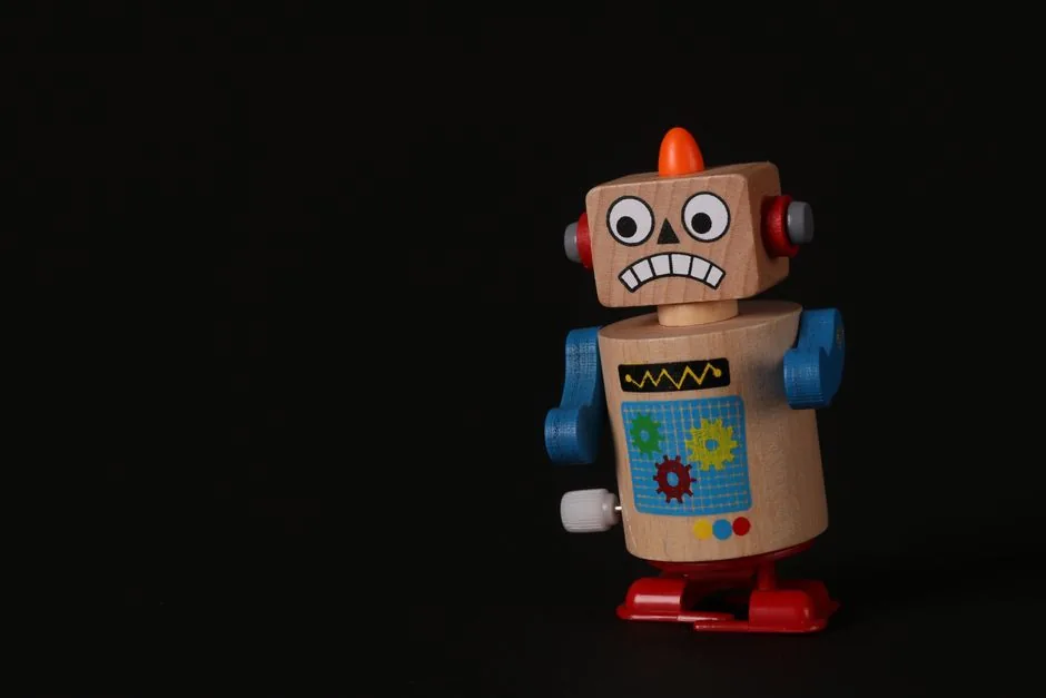 A vibrant wooden toy robot stands on a dark surface, showcasing vivid colors and playful design.