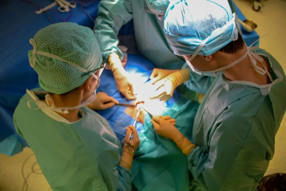 Surgeons in sterile attire performing surgery with precision in a hospital operating room.
