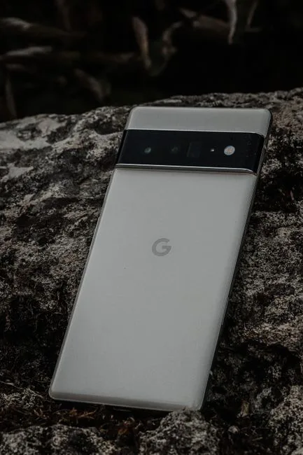 Close-up of a sleek camera phone on textured stone, showcasing modern design.