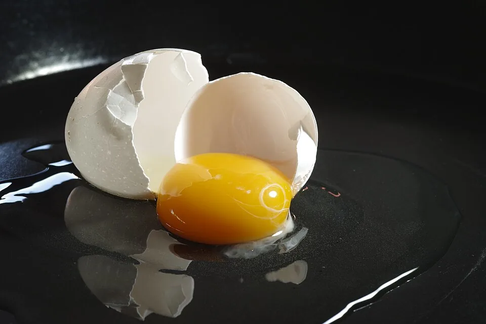Broken egg on black surface
