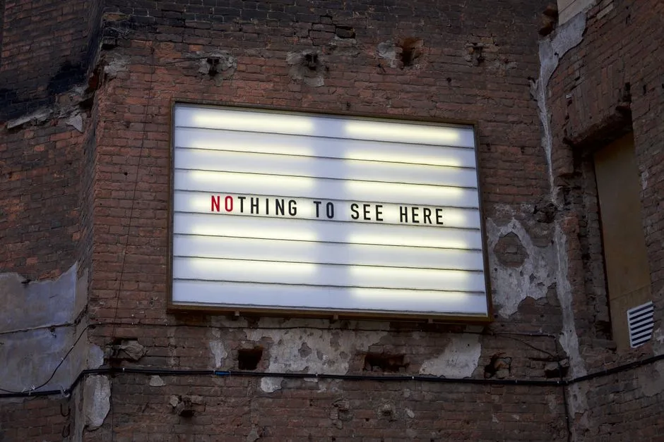 An old marquee on a weathered brick wall displaying the phrase 'Nothing to See Here.'
